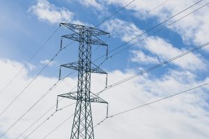 An electric towers with a blue cloudy sky in the background