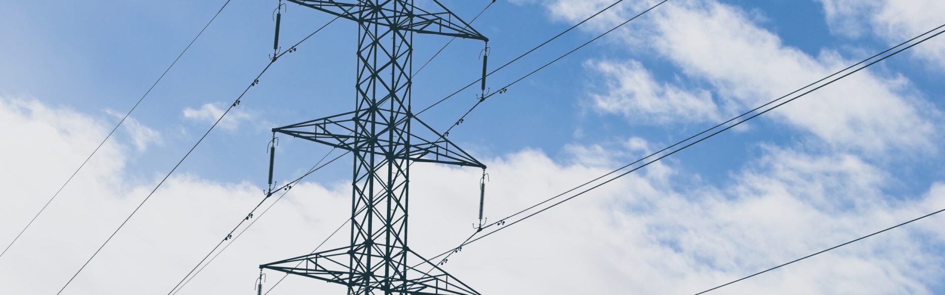 An electric towers with a blue cloudy sky in the background