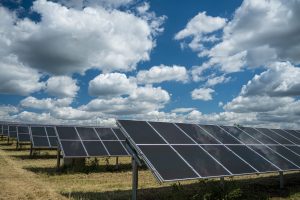 The solar panels used for renewable energy on the field under the sky full of clouds
